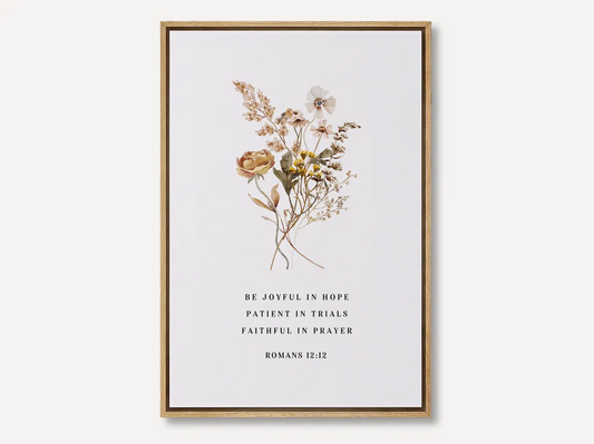 Anchor your heart in hope and resilience with this inspiring Christian canvas wall art. This framed canvas print features a beautiful pressed floral illustration paired with the powerful encouragement from Romans 12:12 to be joyful, patient, and faithful.