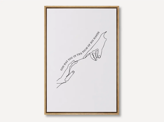 Find comfort and security in God's grasp with this inspiring Christian canvas wall art. This framed canvas print features a beautiful, modern line-art illustration of two hands meeting, highlighting the powerful promise from Isaiah 49:16: “God has you in the palm of His hands.”