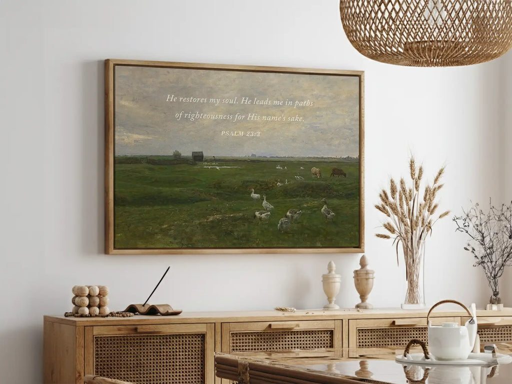 Invite peace and renewal into your space with this inspiring Christian wall art. This framed print features a calming pastoral landscape paired with the comforting promise from Psalm 23:3 about the restoration of the soul.