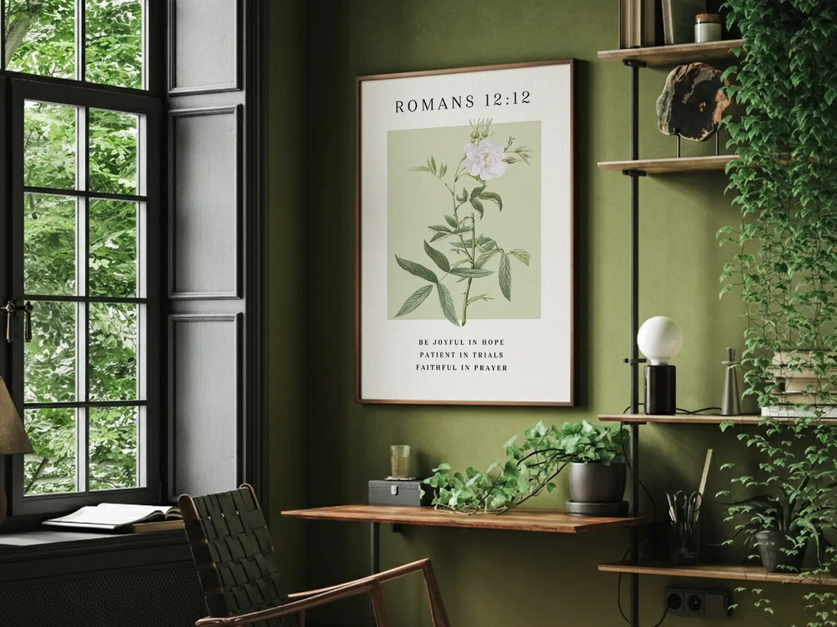 Botanical Christian wall art with Bible verse Romans 12:12 framed and hanging above a neutral sofa