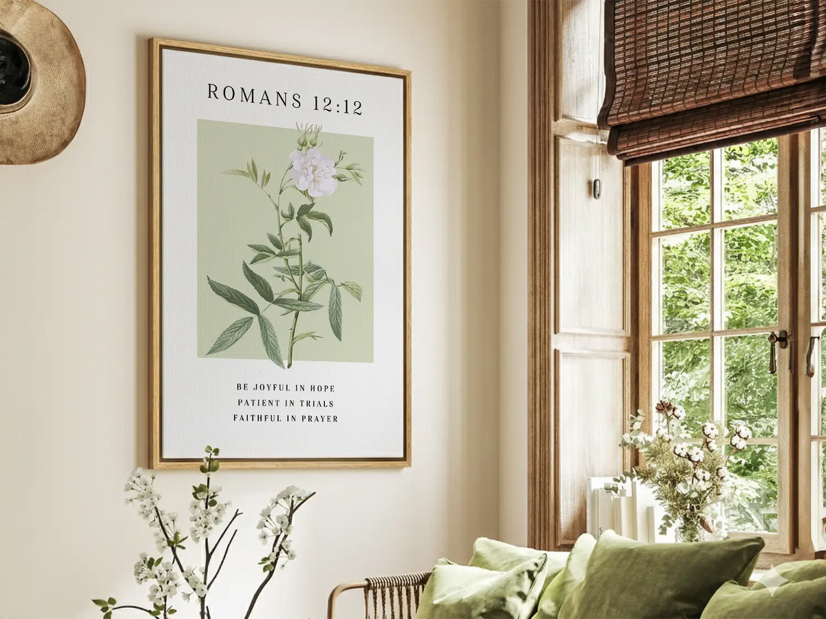 Christian floral scripture canvas wall art Romans 12:12 displayed in a bright living room with natural light