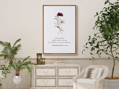 Anchor your heart in daily joy and gratitude with this inspiring Christian canvas wall art. This framed canvas print features a delicate watercolor floral illustration paired with the essential life commands from 1 Thessalonians 5:16-18.