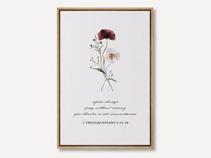 Anchor your heart in daily joy and gratitude with this inspiring Christian canvas wall art. This framed canvas print features a delicate watercolor floral illustration paired with the essential life commands from 1 Thessalonians 5:16-18.