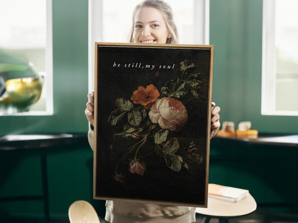 Invite deep tranquility and faith into your home with this inspiring Christian canvas wall art. This framed canvas print features a dramatic, dark floral painting paired with the comforting command: “Be still, my soul.”